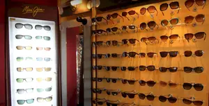 A wall of sunglasses including brown, black and orange lenses.