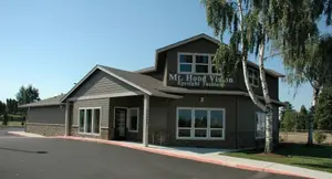 Mt. Hood Vision Eyesight Fashion building with a gray exterior, several windows, and a sign that reads 'Mt. Hood Vision Eyesight Fashion'.