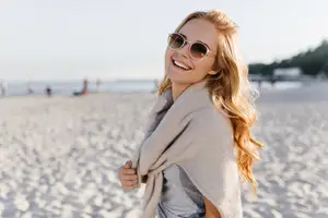 Woman smiling on the beach with a shawl on