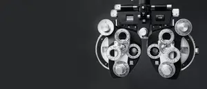 A close-up of an optometrist's refractor, a tool used for eye examinations, displayed on a black background.