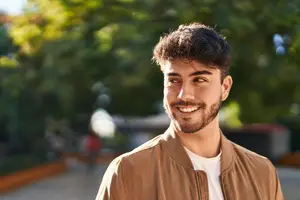 A man standing outside and smiling at the camera
