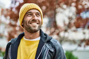 Man in yellow hat and jacket smiling at camera