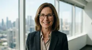 A woman standing in front of windows with a city view