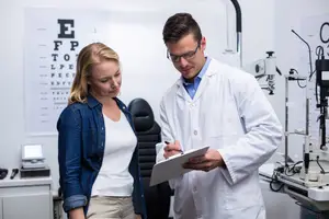 A ophthalmologist and optometrist in a medical office, discussing a patient eye health history