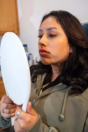 A woman looking into a mirror with her lips puckered