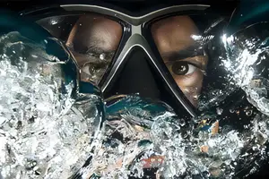 A close up of a person's face with a mask over their eyes in the water.