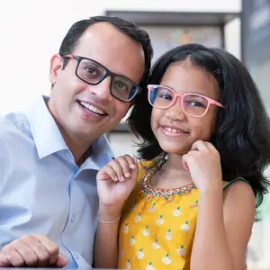 A man and a young girl are smiling and posing for a photo while sitting at a table.