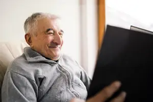 Elderly man reading a book and smiling