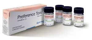 Four small vials of medication are arranged next to a larger box labeled Preference Toric, which contains Tinted Soft Contact Lenses.