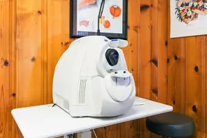 a white ophthalmic machine on a white table in an optometrists office