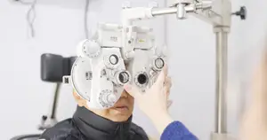 An elderly man is getting an eye test at an eye clinic with an eye doctor