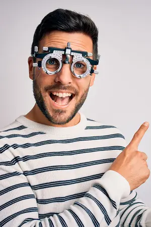 A smiling man wearing a white long-sleeve shirt and a pair of black and silver glasses with black lenses and silver frames.
