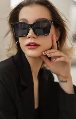 Woman with short hair and black sunglasses posing for a photo