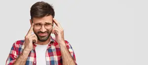 Man with a headache holding his head with both hands