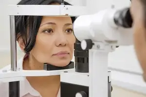 An adult woman is undergoing an eye examination in a clinic