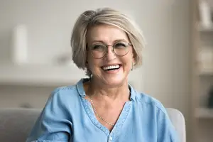 Elegant elderly woman sitting on a couch and smiling