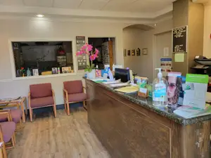 A wooden reception desk with a flower and a monitor on it