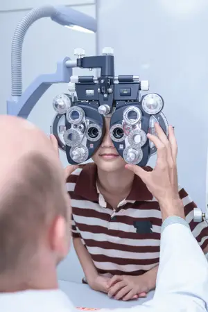 A doctor is examining a child's eyes using an ophthalmoscope in a clinic.