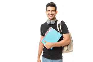 Image of a student holding books and a backpack, smiling and posing for the camera