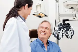An optometrist is examining a patient's eyes using a machine