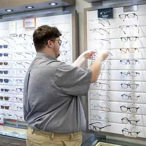 A man is adjusting glasses in a store