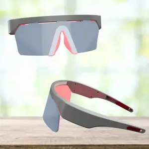 Two pairs of sports goggles with red and grey frames on a wooden surface