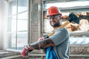 Construction worker holding a hammer in an unfinished building