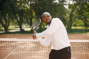 A man playing tennis on a tennis court with a tennis racket