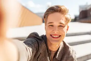 A young man taking a selfie with a smile on his face