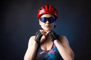 A woman wearing a red helmet and sunglasses is posing for a picture