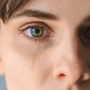 A close up of a woman's face with tears in her eyes
