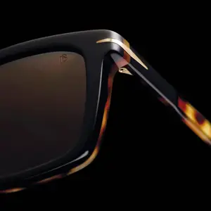 Close up of sunglasses with a black frame and brown lenses
