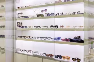A close up of many pairs of sunglasses in different colors and styles on display in a store.