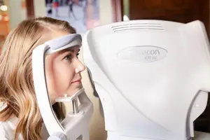 A woman is getting an eye test with a Topcon KR-800 autorefractor.