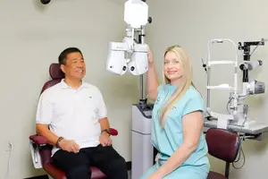 A man and a woman in a room with medical equipment and chairs