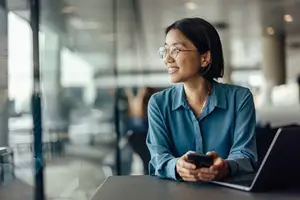 woman sitting in a coffee shop looking at her phone