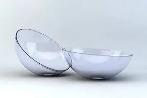 A transparent bowl is placed on a white surface with its bottom part open, casting a reflection on the bowl's surface.