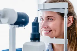 Woman using an eye exam machine while smiling