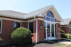 A brick building with a gray roof and glass windows, displaying a sign reading 'St. Westtown Eye Care', located on a sunny day.