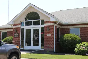 A car parked in front of a brick building with a glass window and a sign that reads Middletown Eye Care