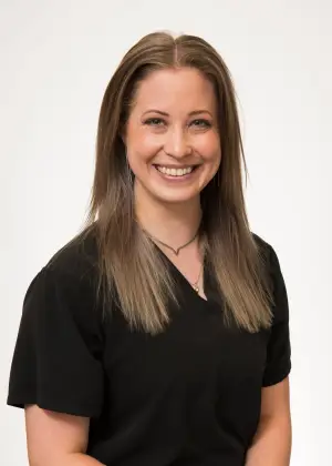 A smiling woman with long blonde hair wearing a black shirt and a necklace