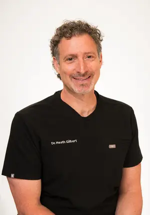 A man wearing a black shirt with the words Dr. Heath Gilbert on it