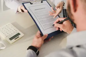 A man and a woman are filling out an insurance claim form.