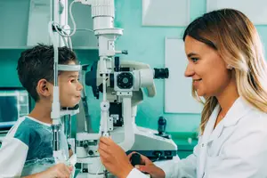 A young boy having his eyes examined by an optometrist