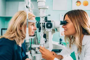A woman doctor examining the eye of a woman patient in a clinic