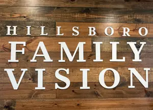 A wooden sign with the text Hillsboro Family Vision mounted on a wooden wall