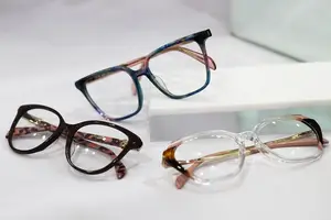Three pairs of glasses with different colors and designs on a white surface.
