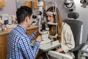 A woman undergoing an eye exam with an optometrist