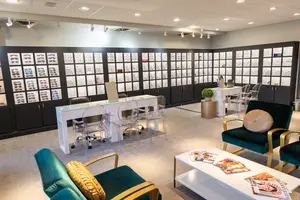 Interior of an eyeglass shop with a display case, chairs, and tables