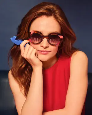 A woman with red hair wearing WOOW sunglasses with pink frames